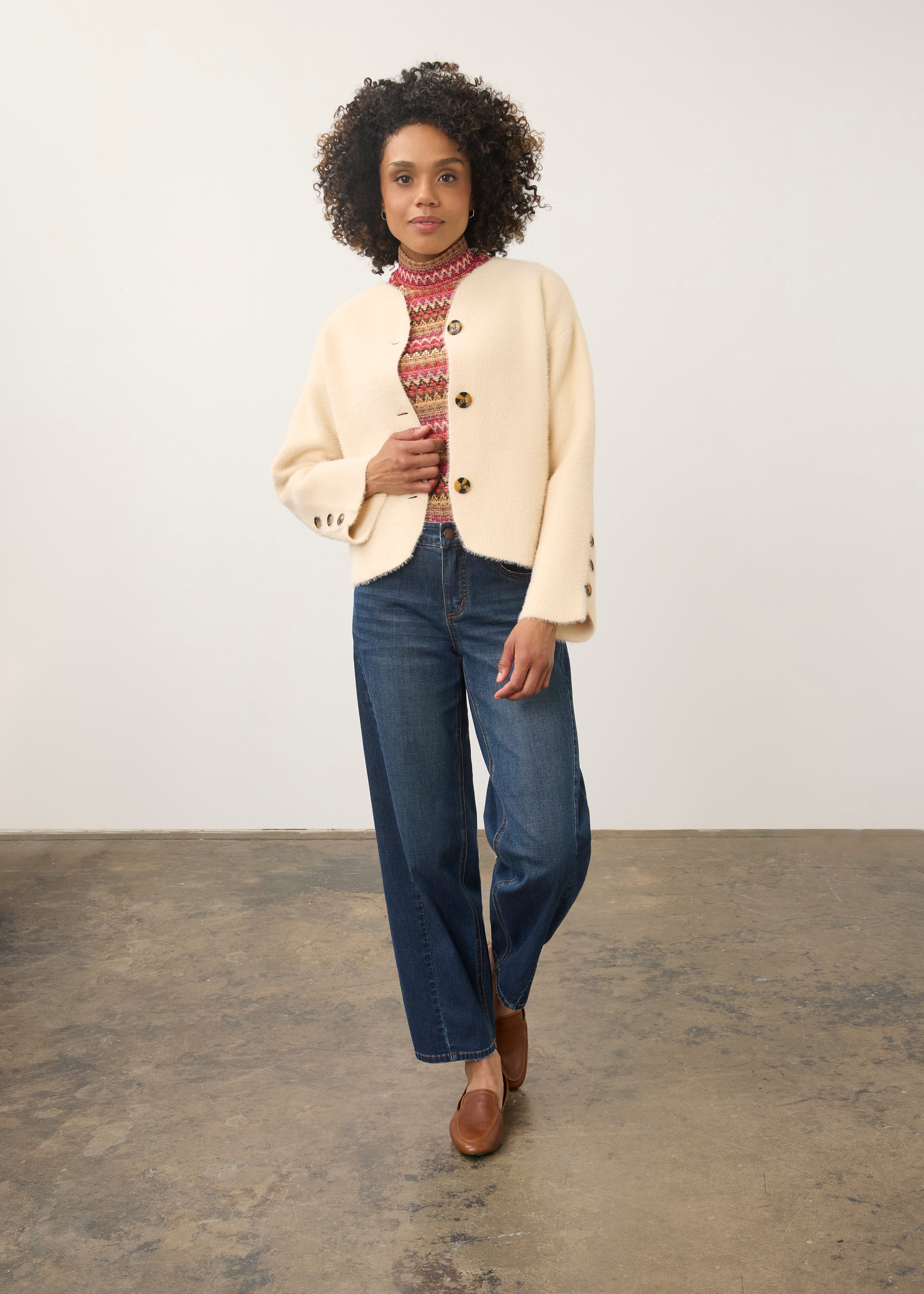Full-body shot of model in cream knit cardigan paired with blue jeans by French Dressing Jeans (FDJ)