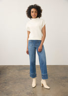 Model wearing white ribbed top with high collar and jeans, full outfit view by French Dressing Jeans (FDJ)