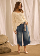 Full-body view of denim culottes with crochet top on sandy background by French Dressing Jeans (FDJ)