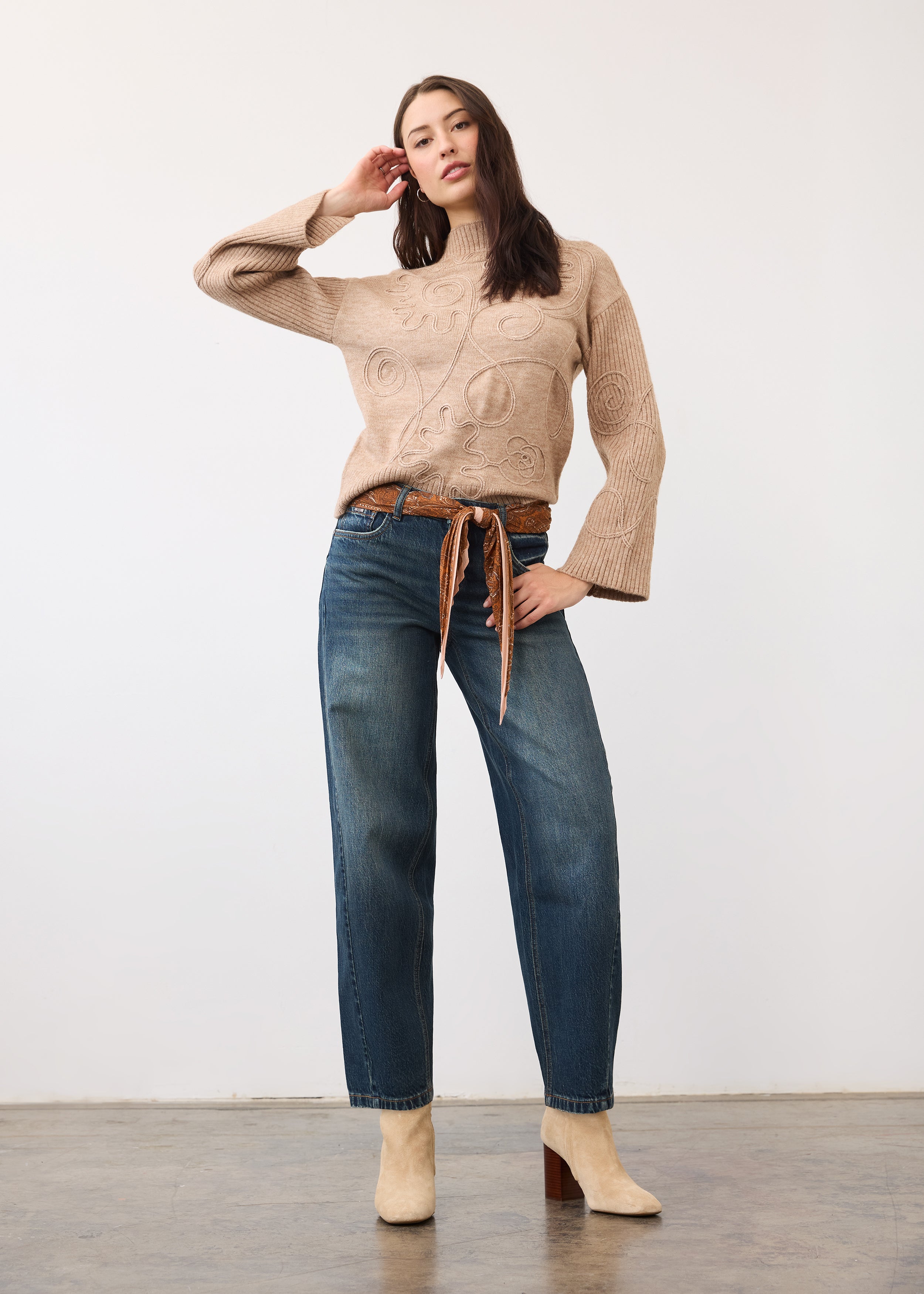 Full view of model in medium blue jeans styled with a belt and boots by French Dressing Jeans (FDJ)
