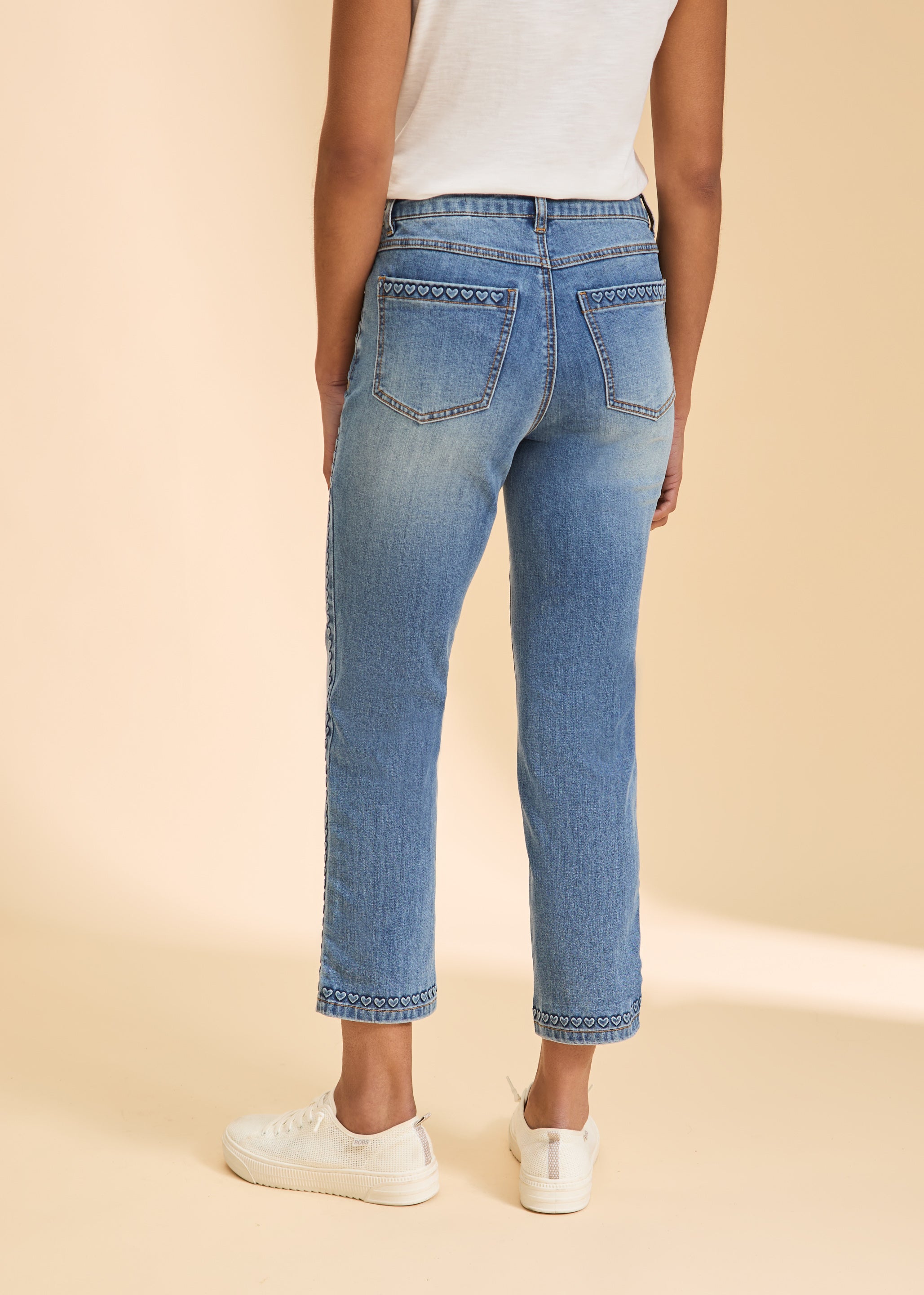 Back view of light wash straight ankle jeans with heart pattern on pockets by French Dressing Jeans (FDJ)