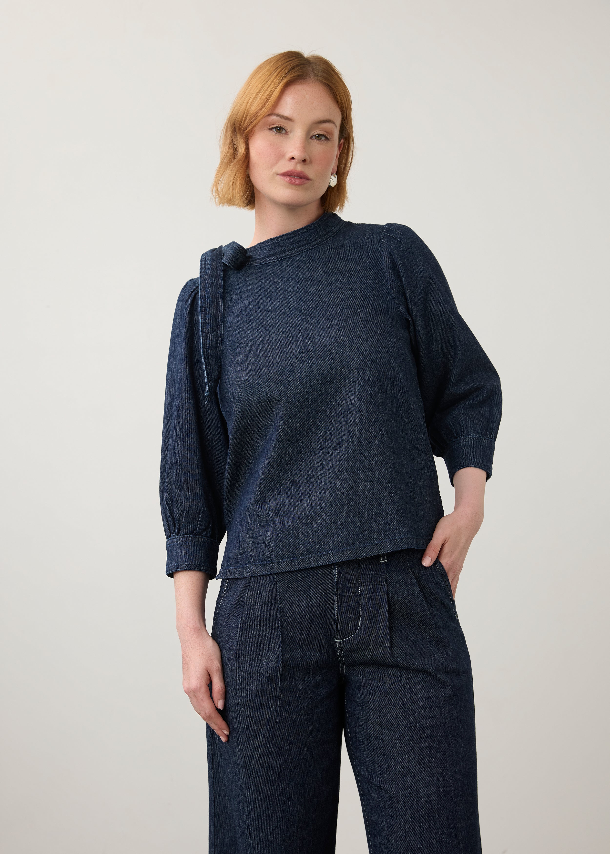 Front view of dark wash puff-sleeve top with wide-leg pants showing pleated waist by French Dressing Jeans (FDJ)
