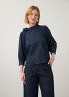 Front view of dark wash puff-sleeve top with wide-leg pants showing pleated waist by French Dressing Jeans (FDJ)