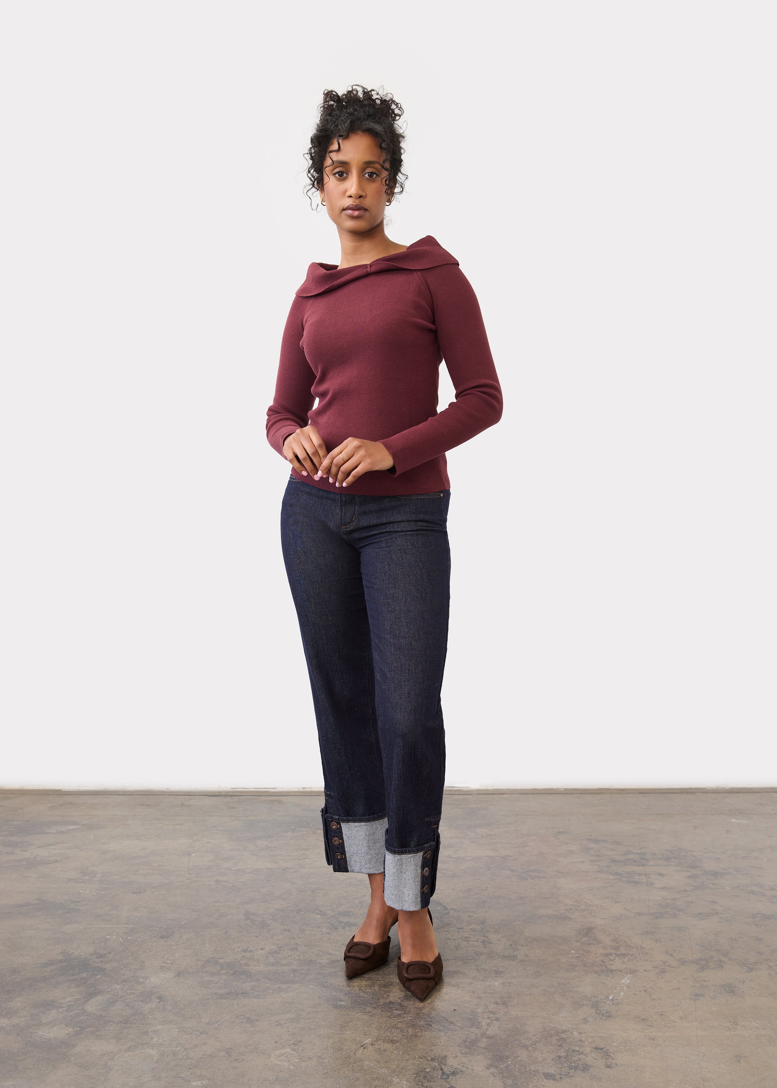 Full body view of burgundy off-the-shoulder sweater styled with cuffed jeans by French Dressing Jeans (FDJ)