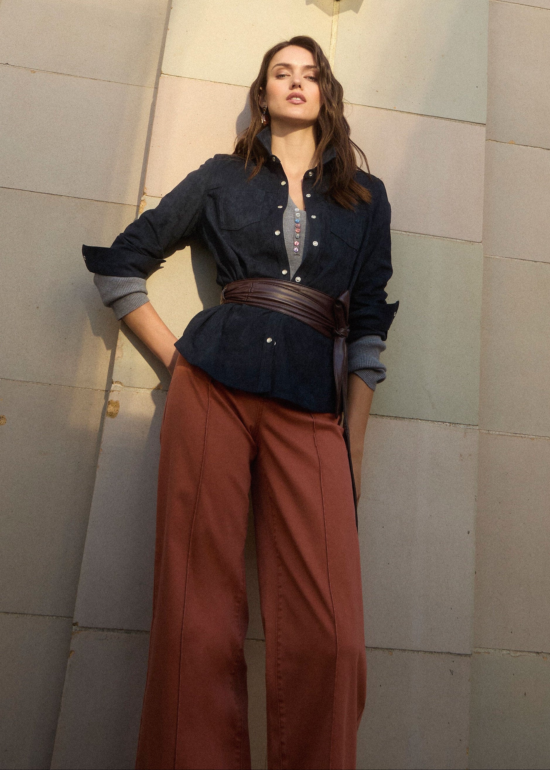 Outdoor shot of model in terracotta wide-leg denim under architectural backdrop by French Dressing Jeans (FDJ) par French Dressing Jeans (FDJ)