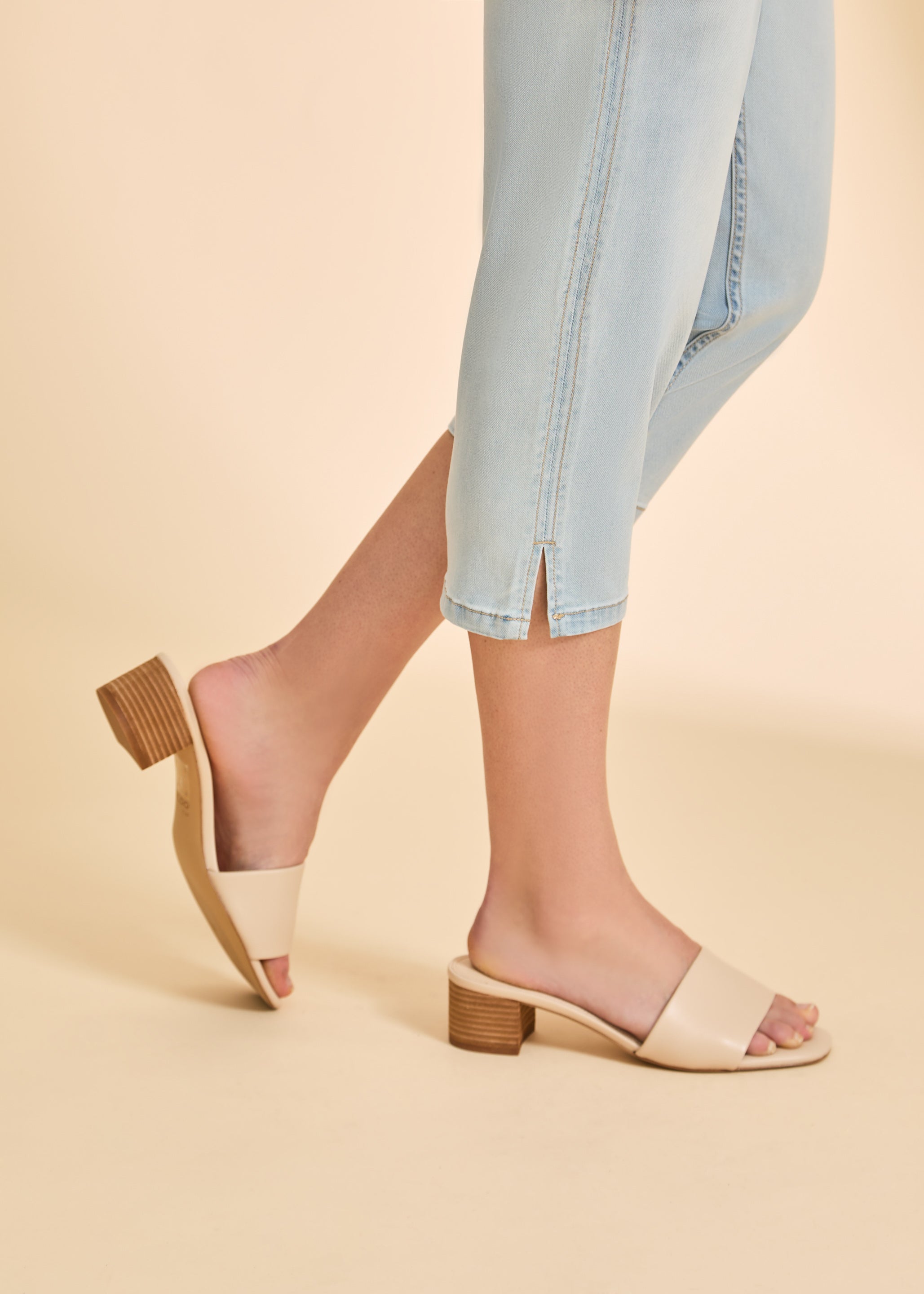 Detail shot of hemline slit on light wash cropped denim pants by French Dressing Jeans (FDJ)