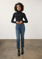 Full body view of black turtleneck top paired with slim-fit jeans by French Dressing Jeans (FDJ)
