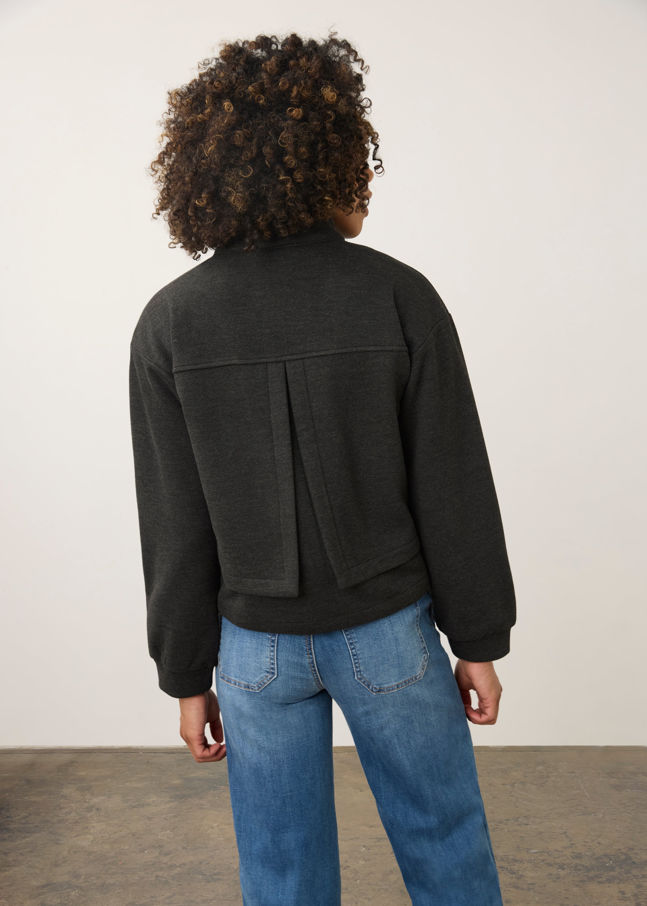 Back view of charcoal knit bomber jacket highlighting pleated detail and relaxed fit by French Dressing Jeans (FDJ)