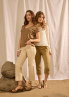 Two women wearing brown and white tops with beige and green bottoms by French Dressing Jeans (FDJ)