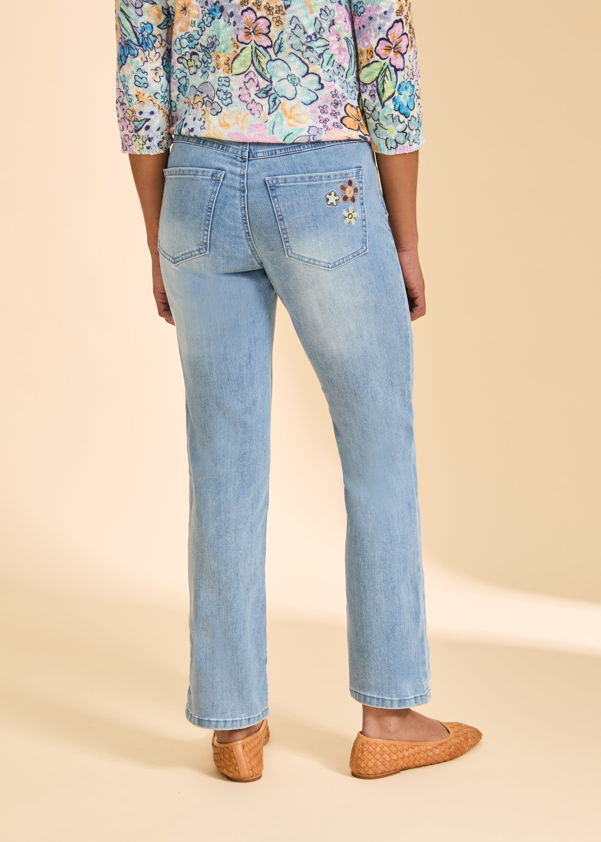 Back view of medium blue denim highlighting rear patch pockets with floral detail by French Dressing Jeans (FDJ)