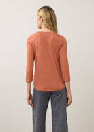 Back view of orange V-neck top featuring simple elegance and smooth silhouette by French Dressing Jeans (FDJ)