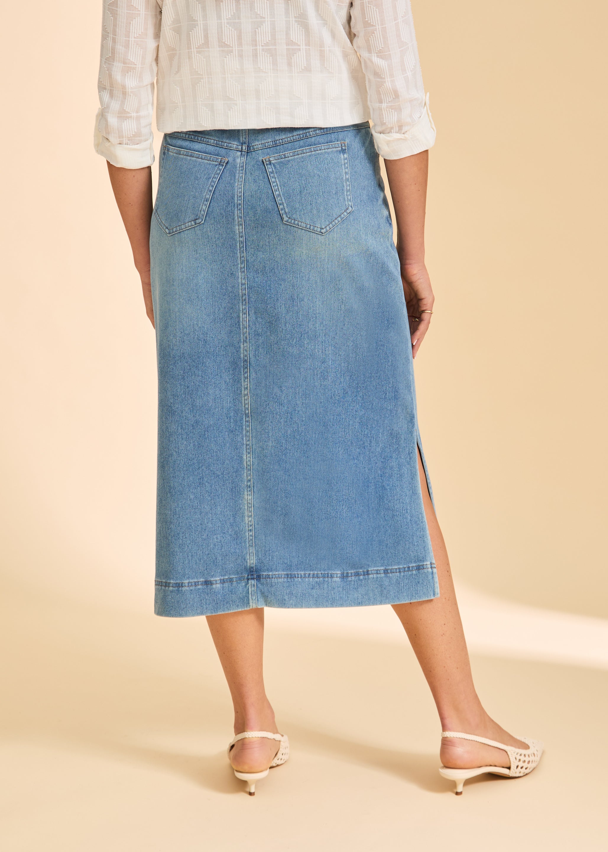 Back view of light blue denim skirt featuring patch pockets and hemline by French Dressing Jeans (FDJ)