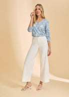 Full outfit view with light blue floral top and white pants, emphasizing V-neck style by French Dressing Jeans (FDJ)