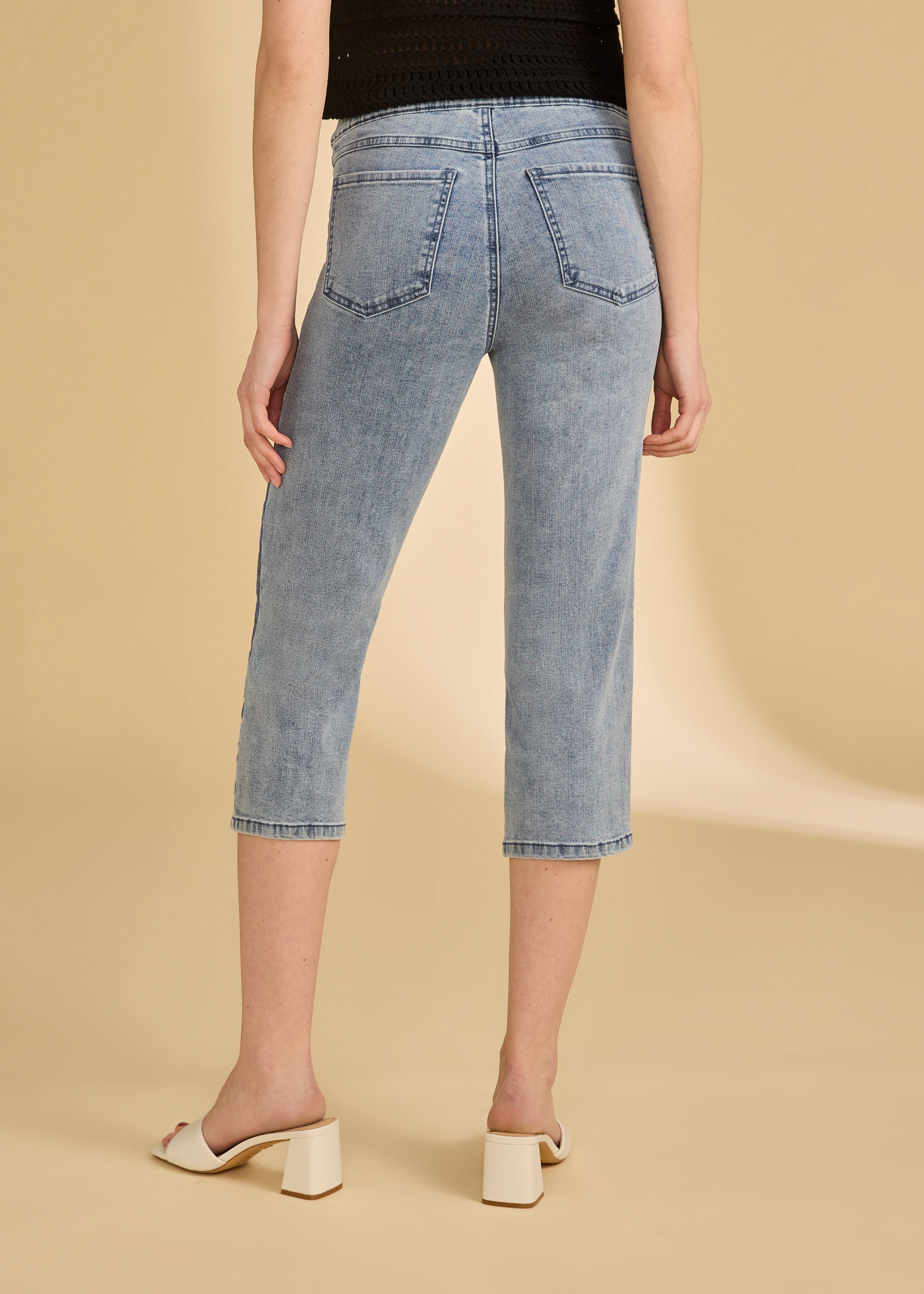 Back view of light medium pull-on capri denim showing patch pockets and slim fit by French Dressing Jeans (FDJ)