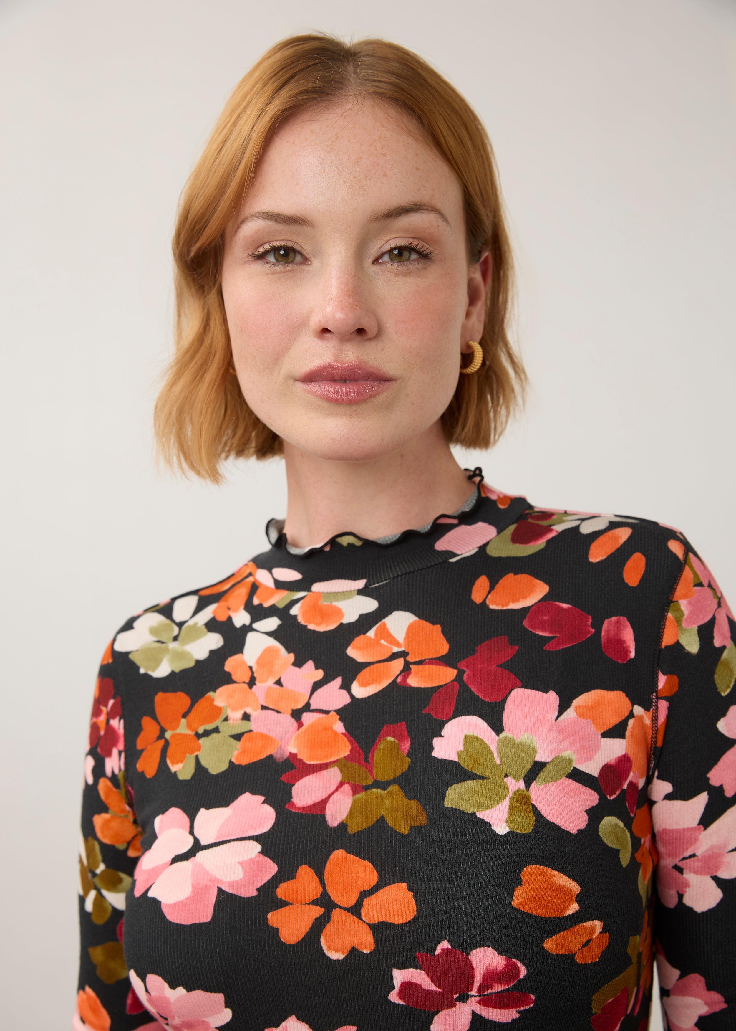 Close-up of vibrant floral top, showcasing detailed pattern and ruffled neckline by French Dressing Jeans (FDJ)