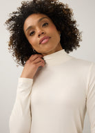 Close-up of cream turtleneck top focusing on neckline and soft stretch fabric by French Dressing Jeans (FDJ)