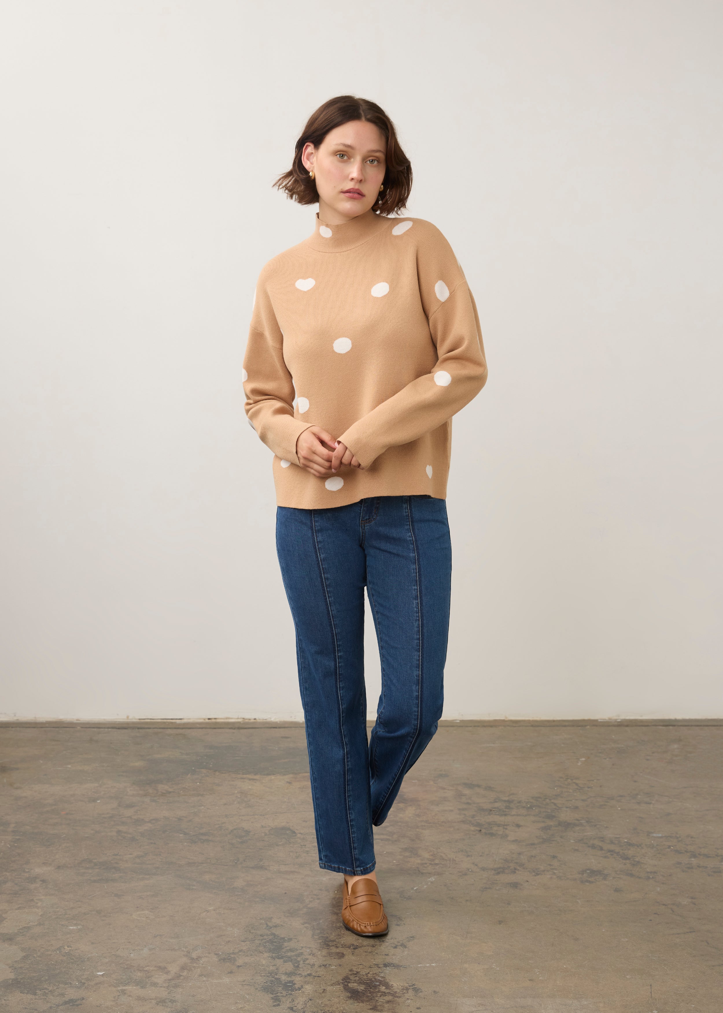 Model in tan polka dot sweater with blue jeans, full outfit view by French Dressing Jeans (FDJ)