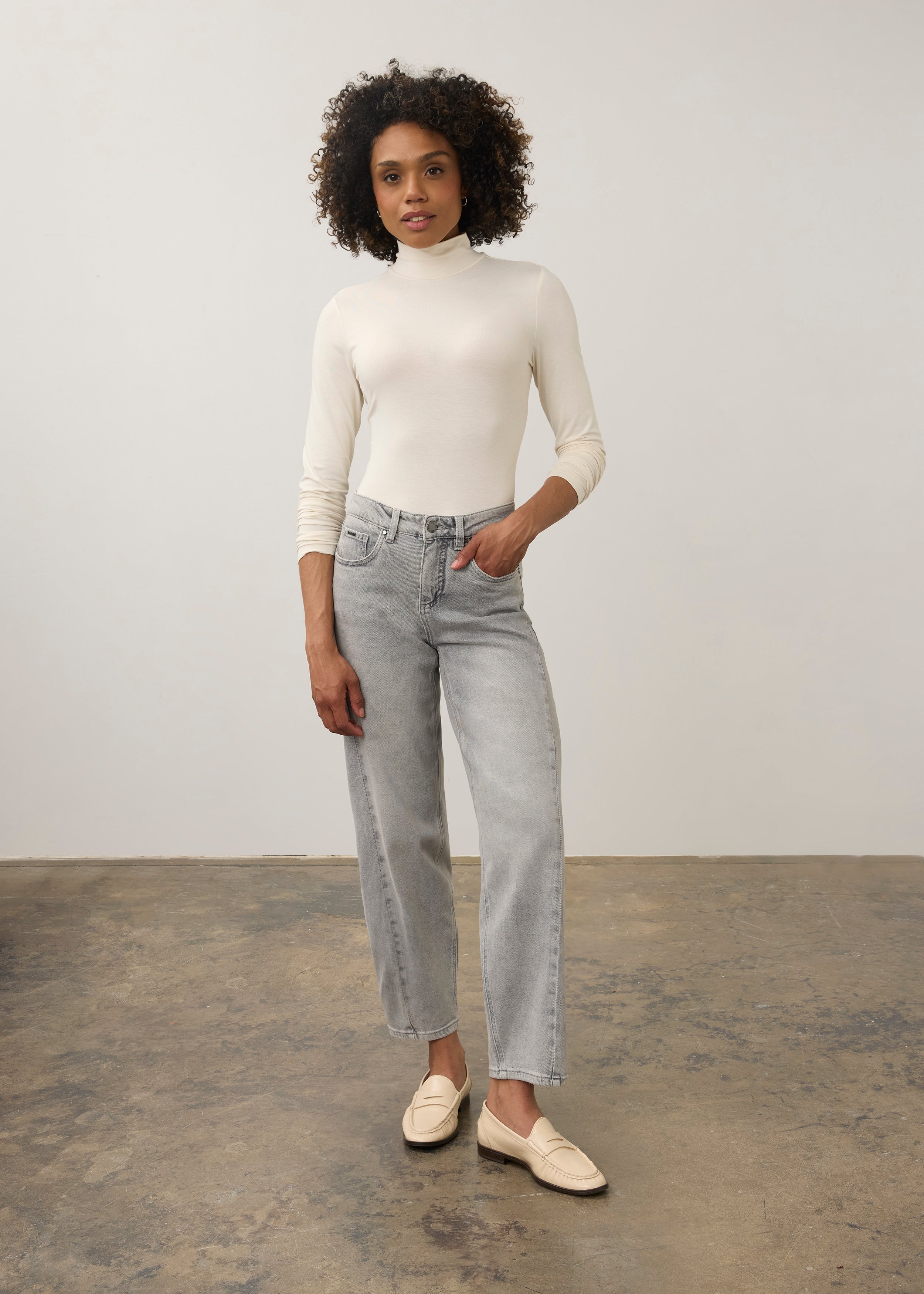 Full body view of cream turtleneck top paired with straight-leg jeans by French Dressing Jeans (FDJ)