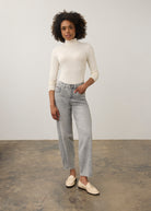 Full body view of cream turtleneck top paired with straight-leg jeans by French Dressing Jeans (FDJ)