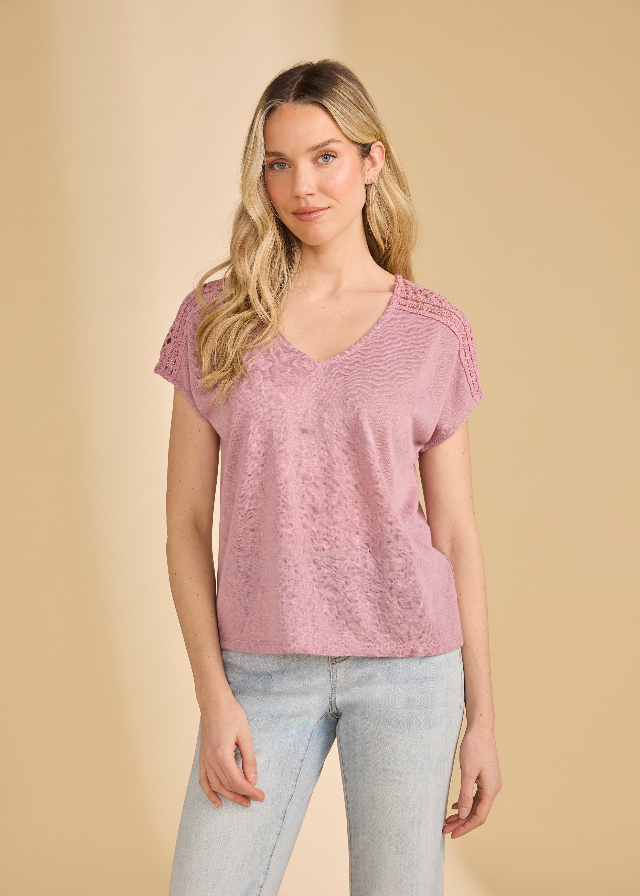 Front view of pink V-neck top with crochet shoulder details paired with jeans by French Dressing Jeans (FDJ)