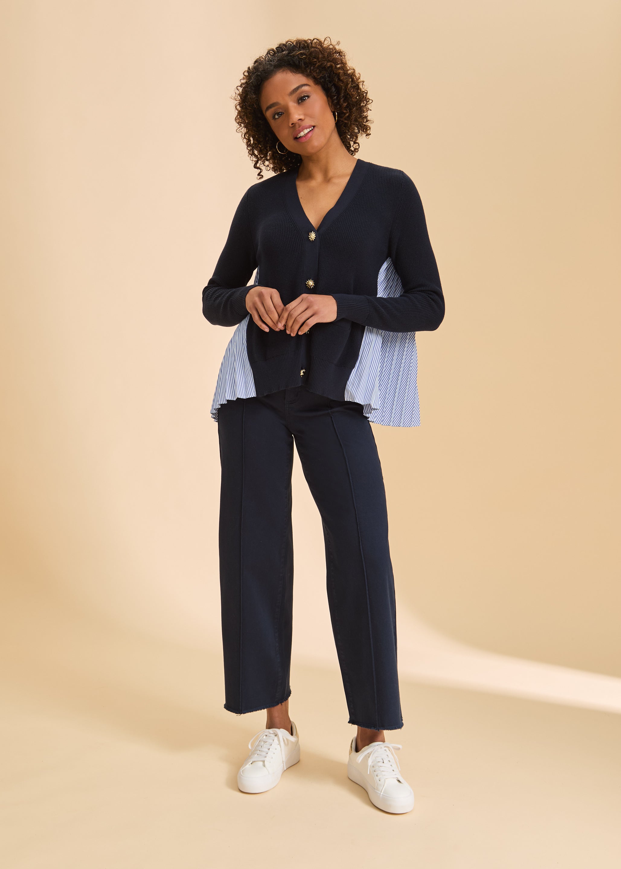 Full view of navy cardigan paired with dark pants and white sneakers by French Dressing Jeans (FDJ)