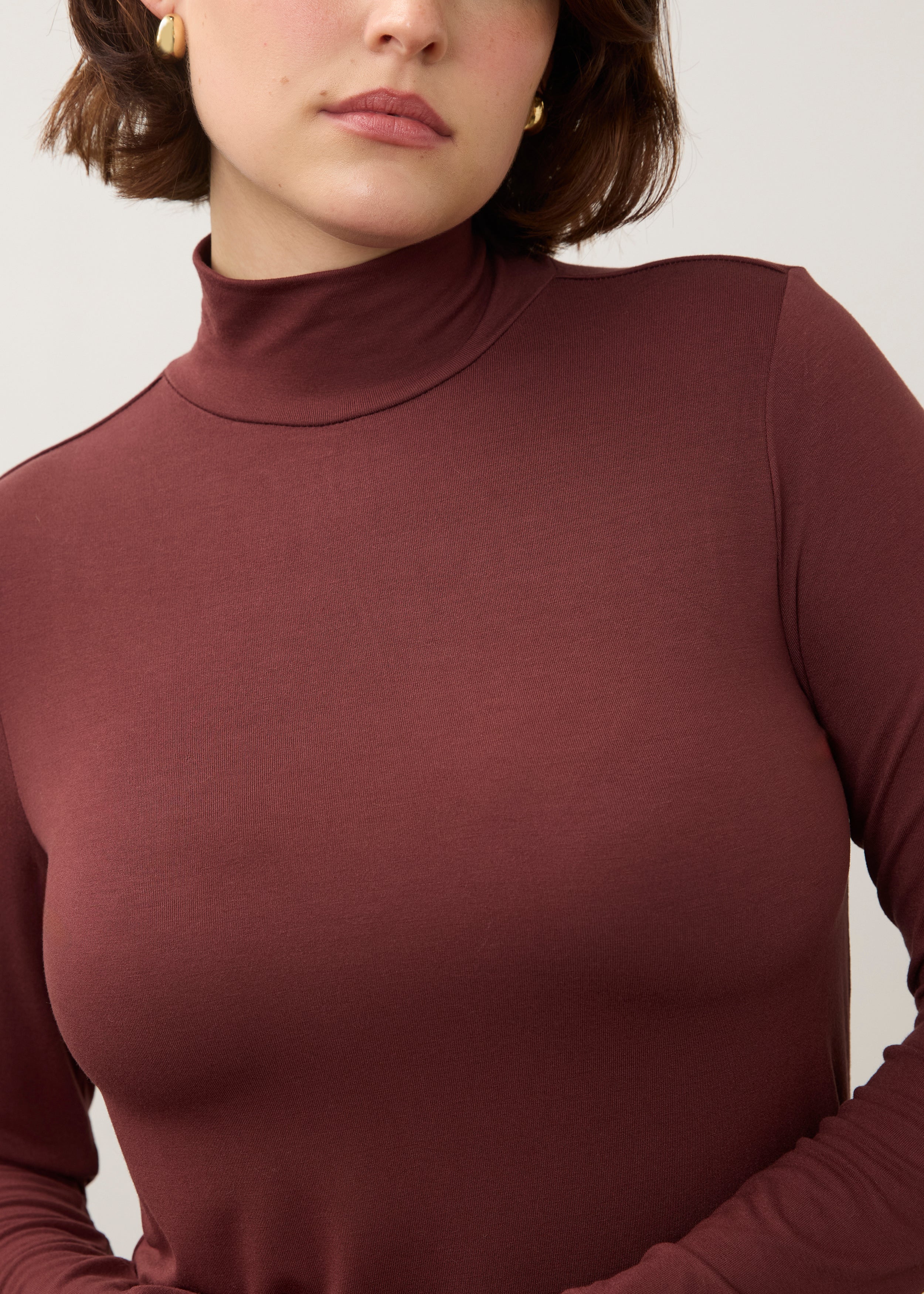 Detail shot of burgundy turtleneck top showing soft texture and fine stitching by French Dressing Jeans (FDJ)