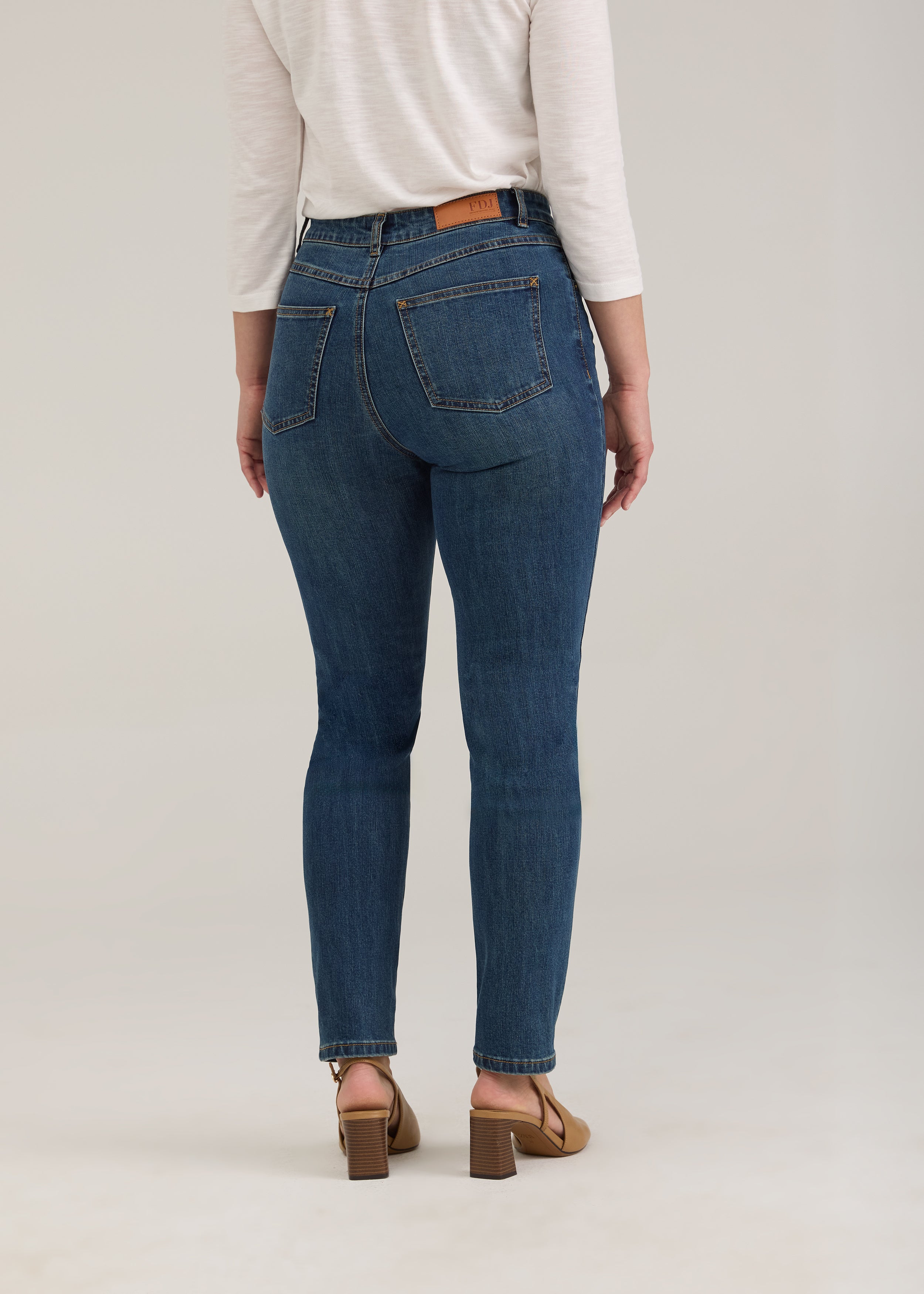 Back view of dark wash jeans showing back patch pockets and snug fit by French Dressing Jeans (FDJ)