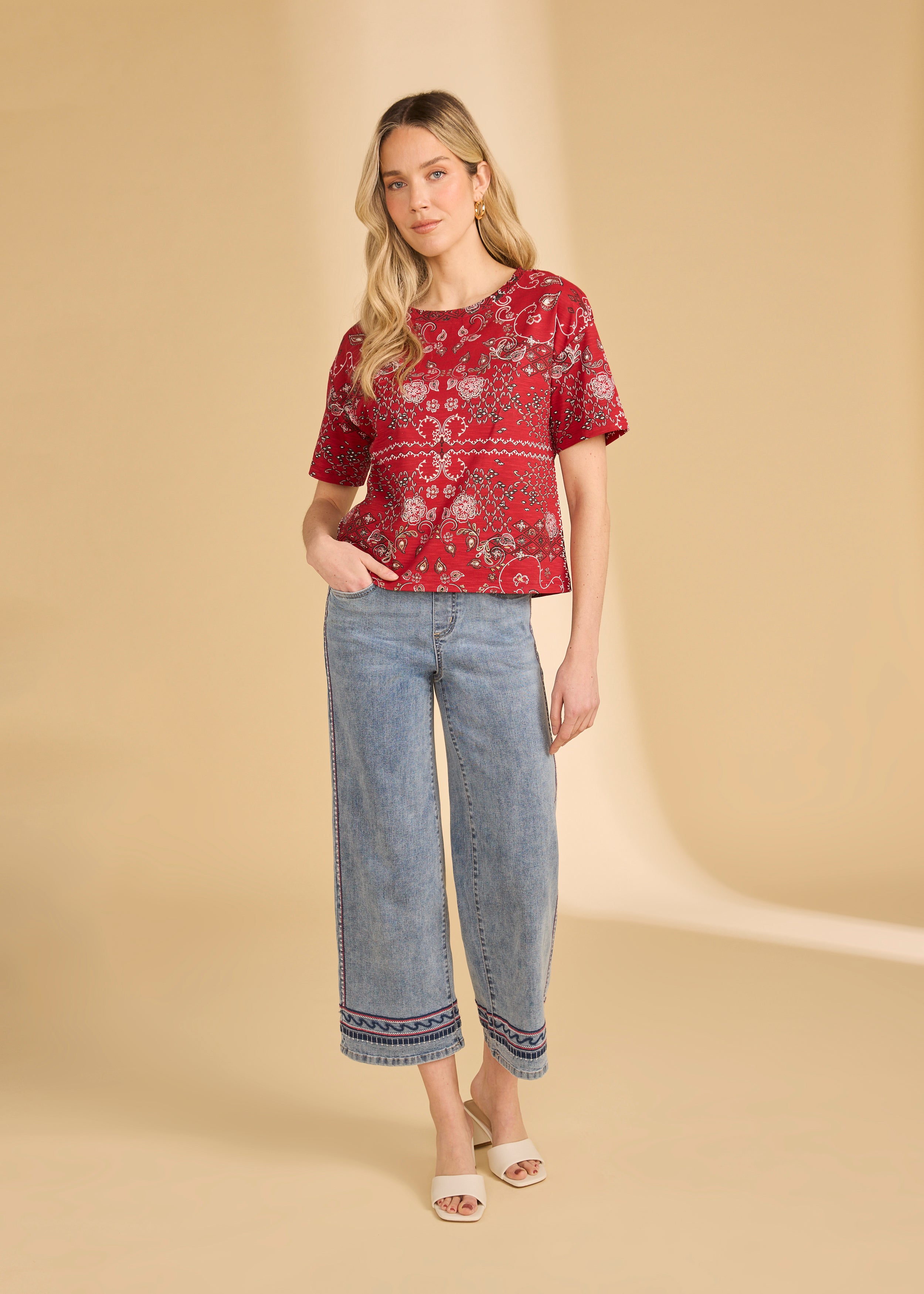 Full body view of red Polynesian block print top with light blue jeans and white sandals by French Dressing Jeans (FDJ)