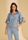 Front view of denim top with floral embroidery and ruffled neckline by French Dressing Jeans (FDJ)