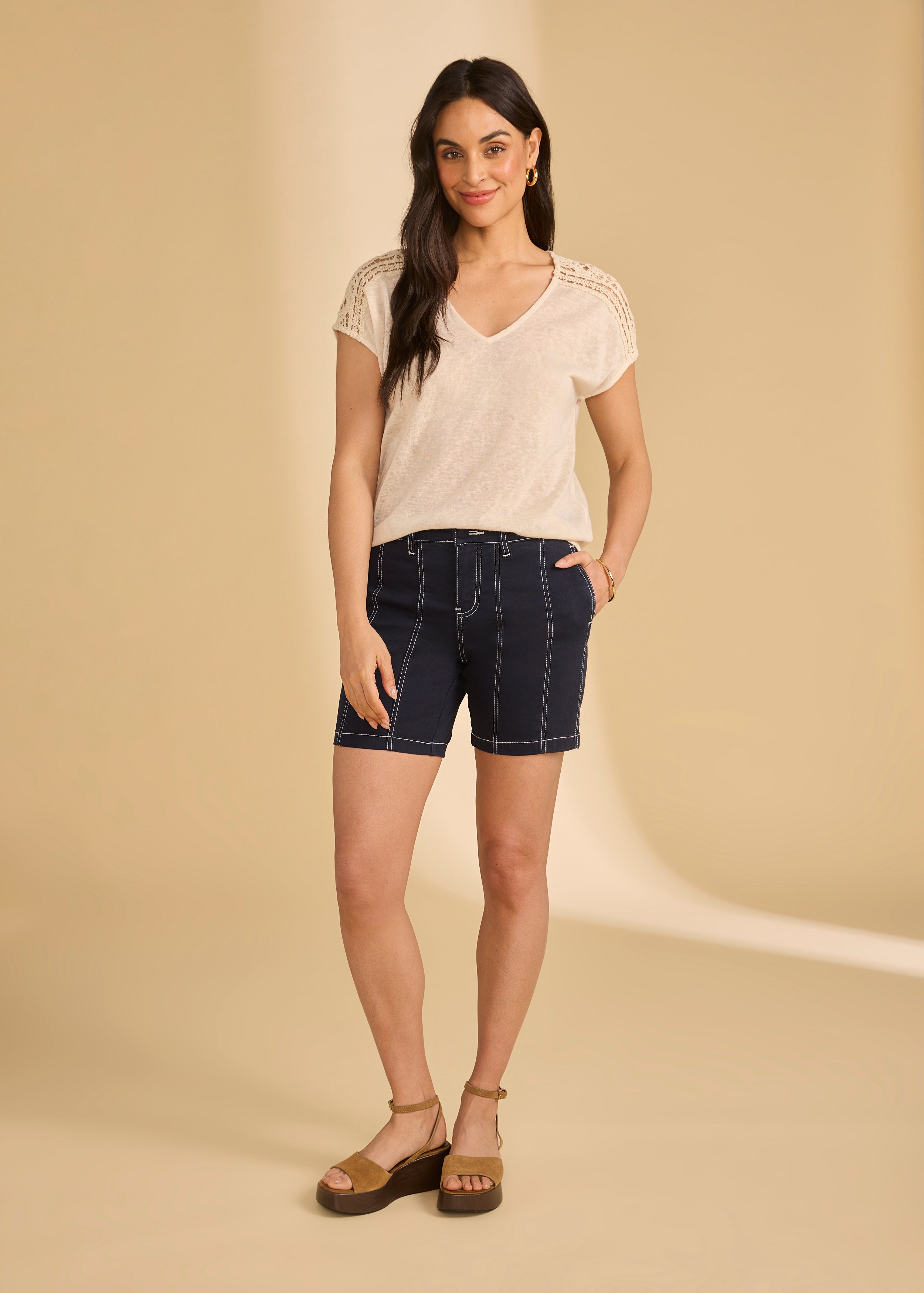 Full view of beige V-neck top paired with navy shorts and sandals by French Dressing Jeans (FDJ)