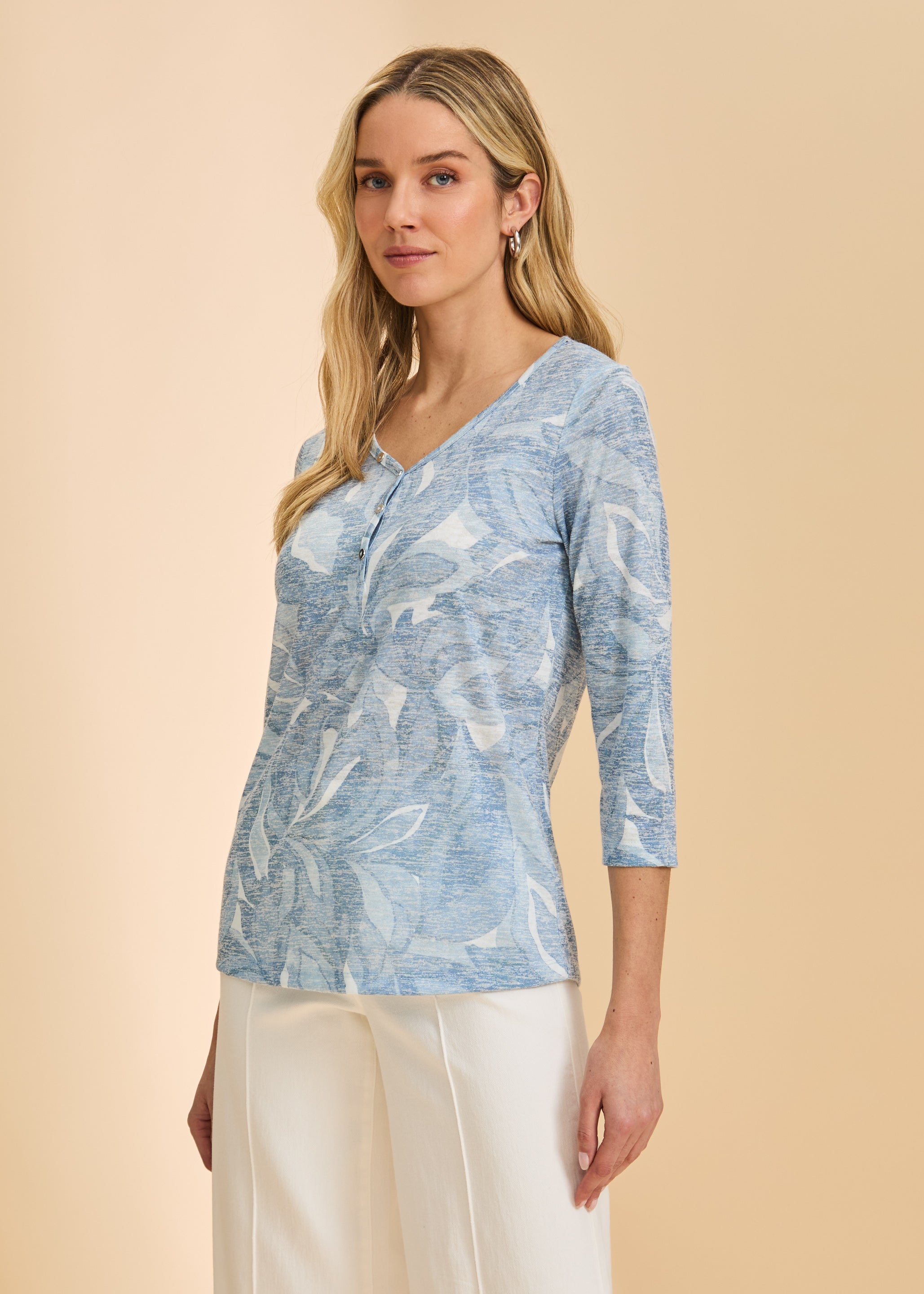 Side view of light blue floral top with 3/4 sleeves and V-neck design paired with white pants by French Dressing Jeans (FDJ)