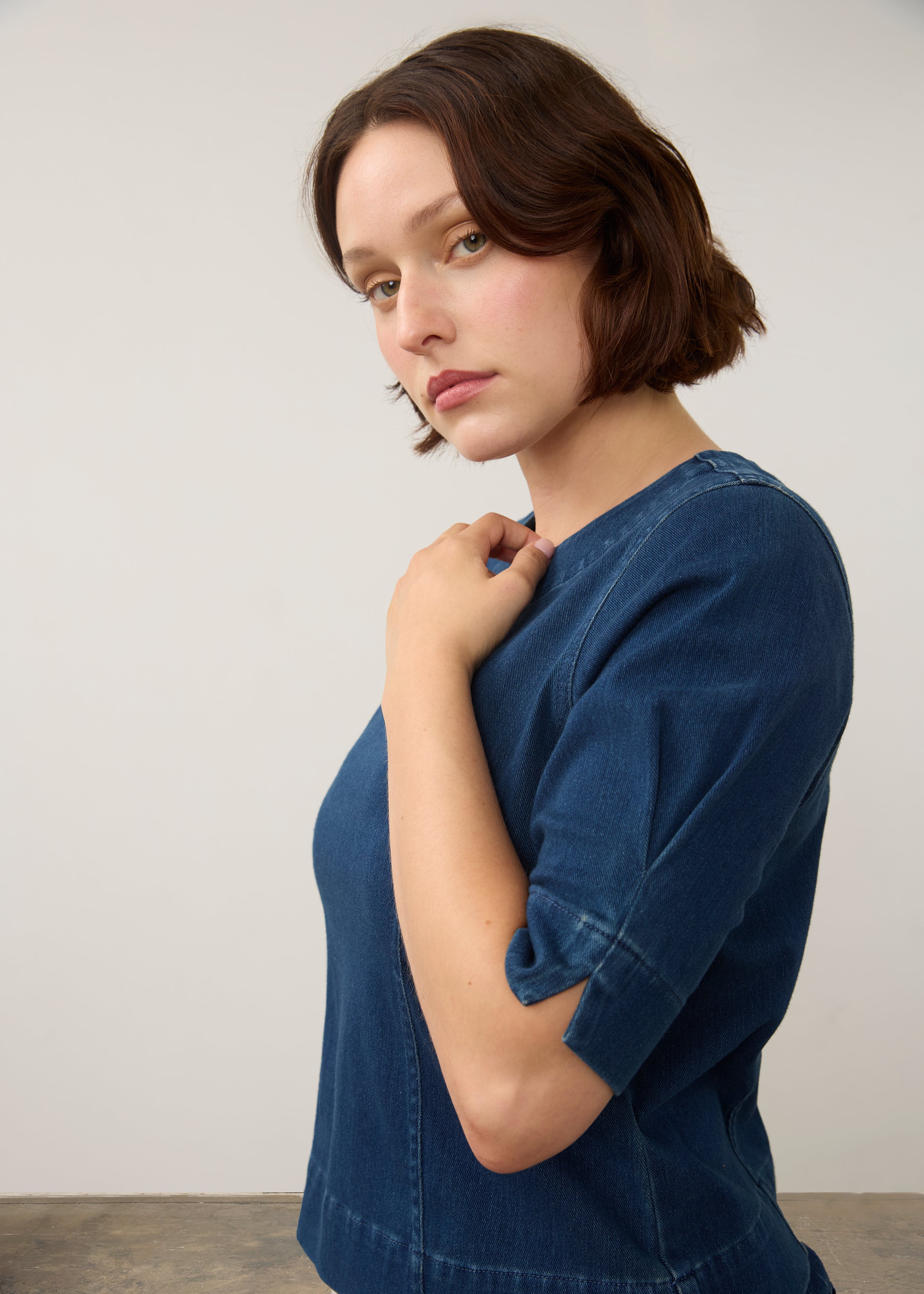 Detail shot of dark rinse fitted top focusing on sleeve design and fabric texture by French Dressing Jeans (FDJ)