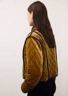 Side view of reversible jacket in brass, displaying quilted pattern and contrasting trim by French Dressing Jeans (FDJ)