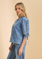 Side profile of chambray shirt emphasizing lace-up sleeve design by French Dressing Jeans (FDJ)