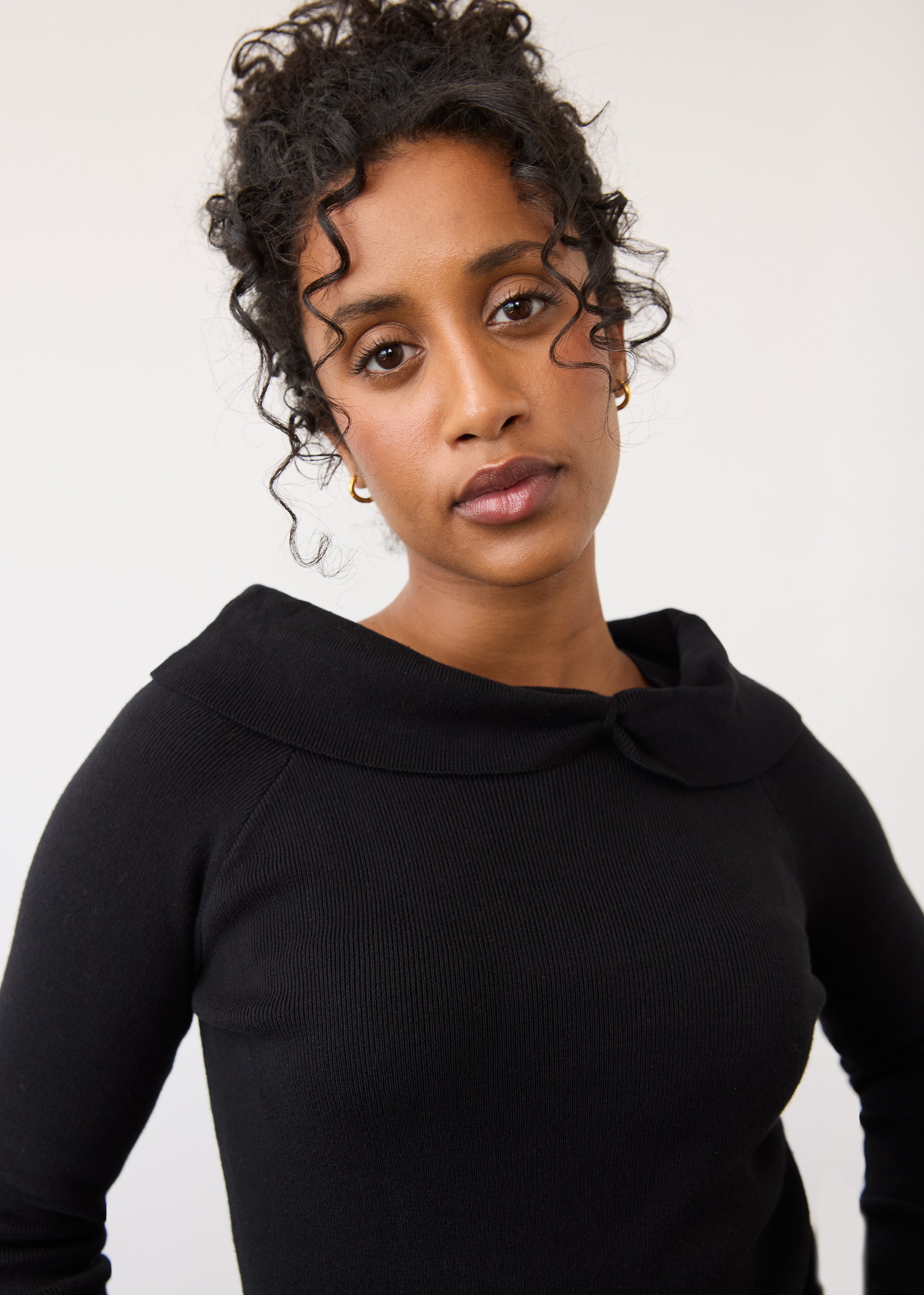 Close-up of black off-the-shoulder sweater focusing on neckline by French Dressing Jeans (FDJ)