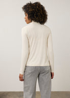 Back view of cream turtleneck top showcasing smooth fabric and seamless design by French Dressing Jeans (FDJ)