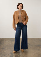 Full-body shot of model in camel knit cardigan styled with dark jeans by French Dressing Jeans (FDJ)