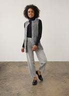 Full-body shot of model in black and white textured vest styled with gray jeans by French Dressing Jeans (FDJ)