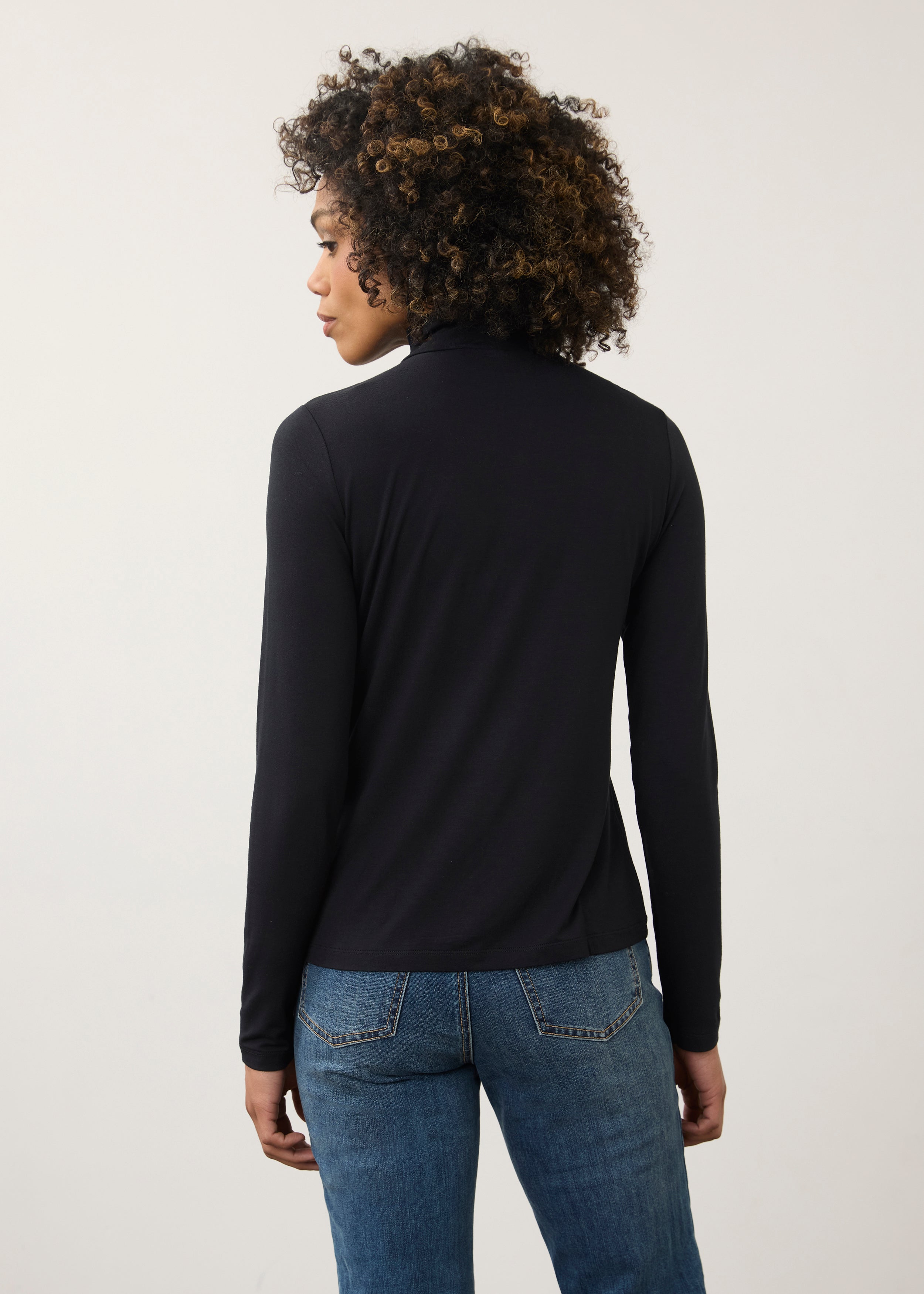 Back view of black turtleneck top highlighting smooth fabric and seamless design by French Dressing Jeans (FDJ)