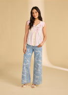 Model in light denim jeans paired with a sleeveless striped top full body view by French Dressing Jeans (FDJ)