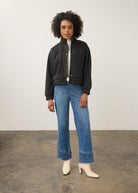 Full-body shot of model in charcoal knit bomber jacket paired with blue jeans by French Dressing Jeans (FDJ)