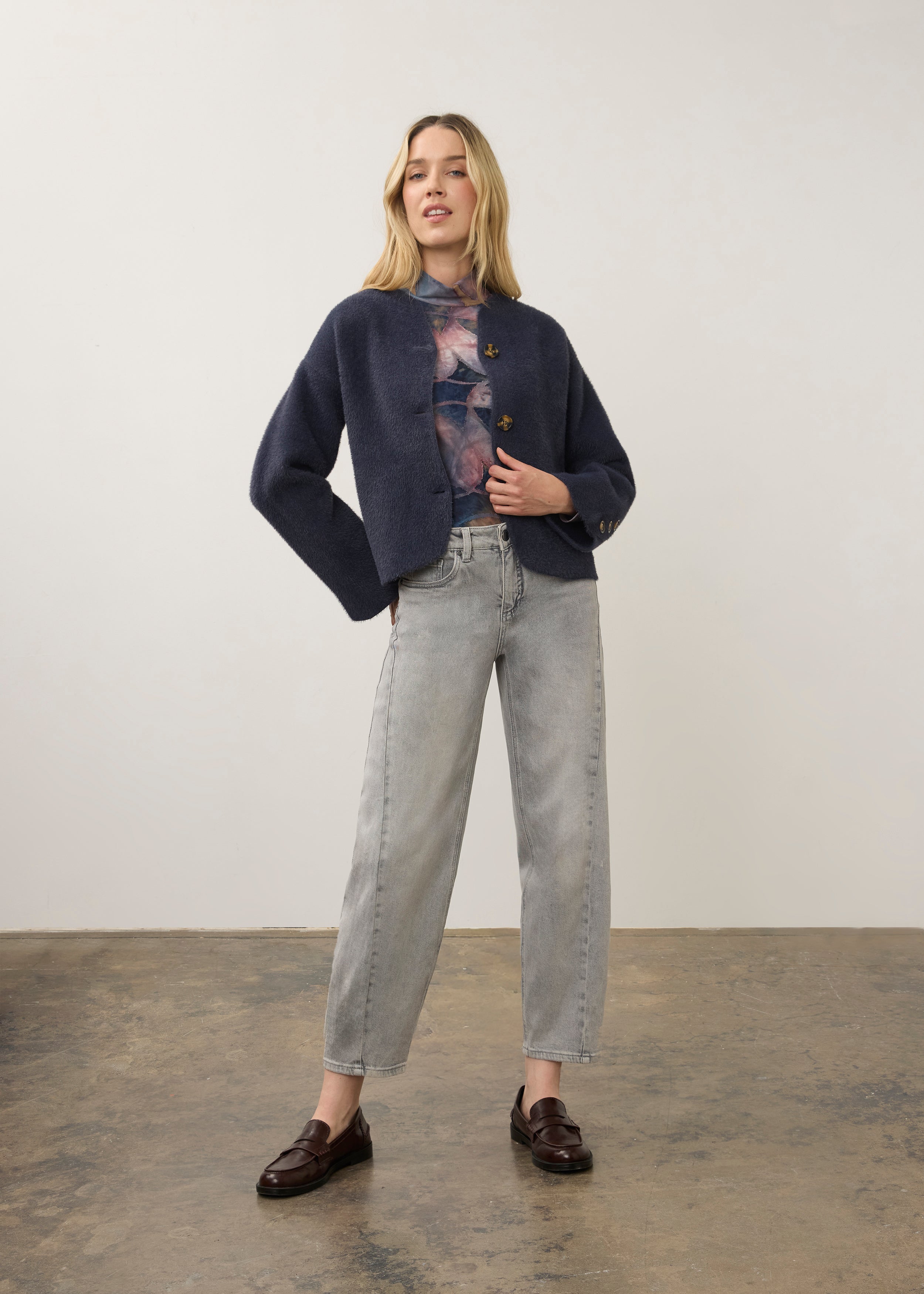 Full-body shot of model in navy knit cardigan with light gray jeans by French Dressing Jeans (FDJ)
