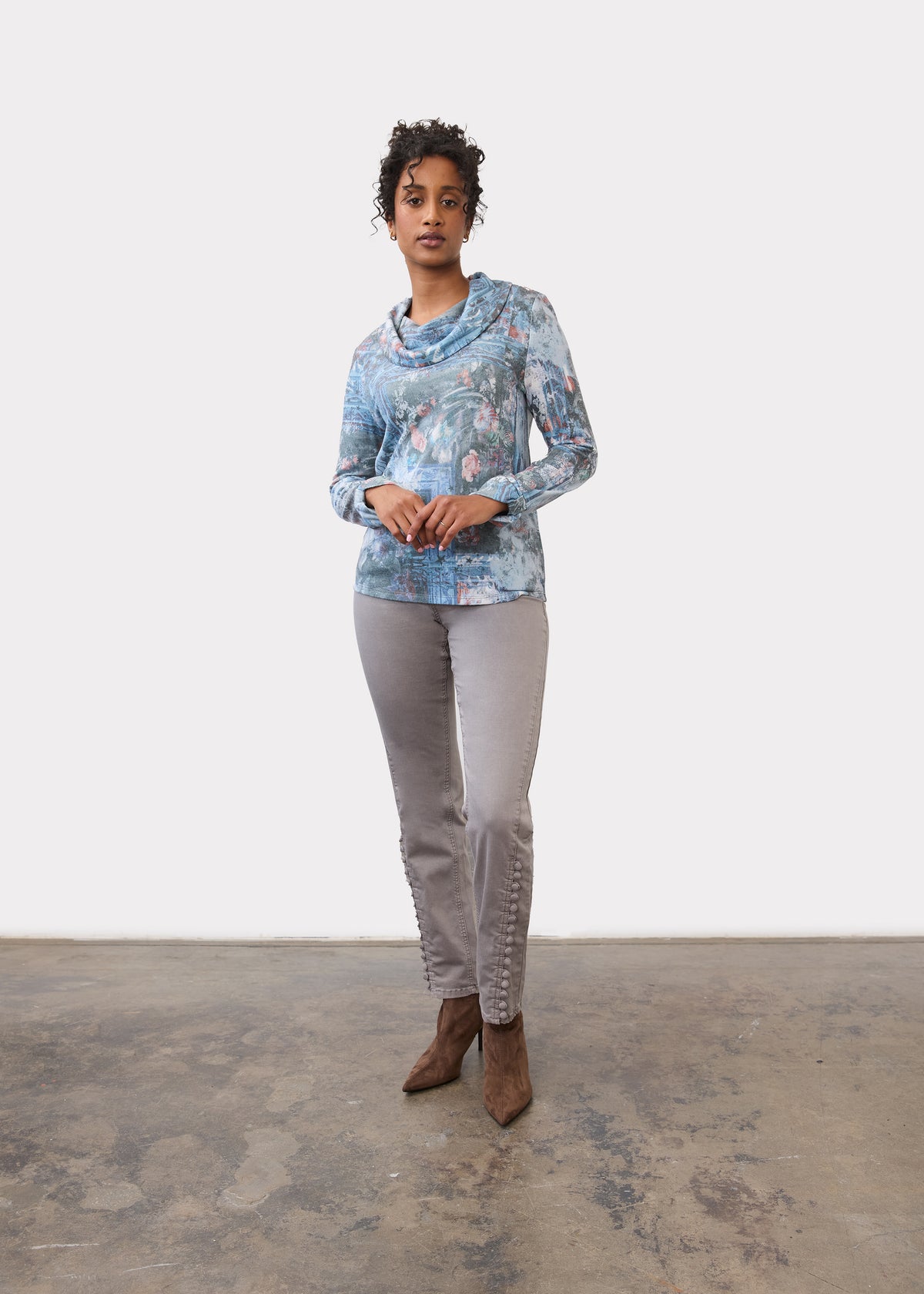 Full view of indigo cowl neck top paired with grey pants and brown boots by French Dressing Jeans (FDJ)