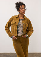 Close-up of model in brass Olivia denim and matching jacket, hands in pockets by French Dressing Jeans (FDJ)