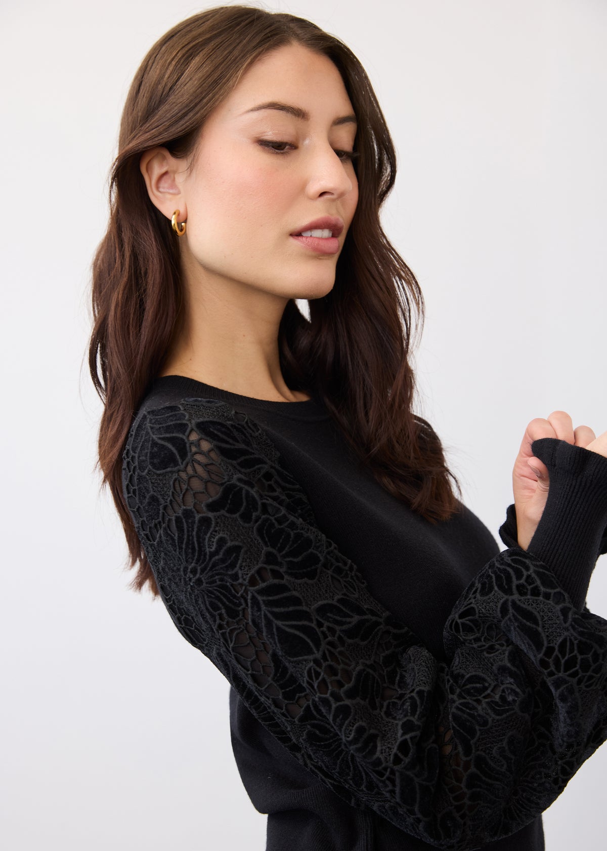 Close-up of floral lace and velvet cut-out sleeve on black sweater by French Dressing Jeans (FDJ)