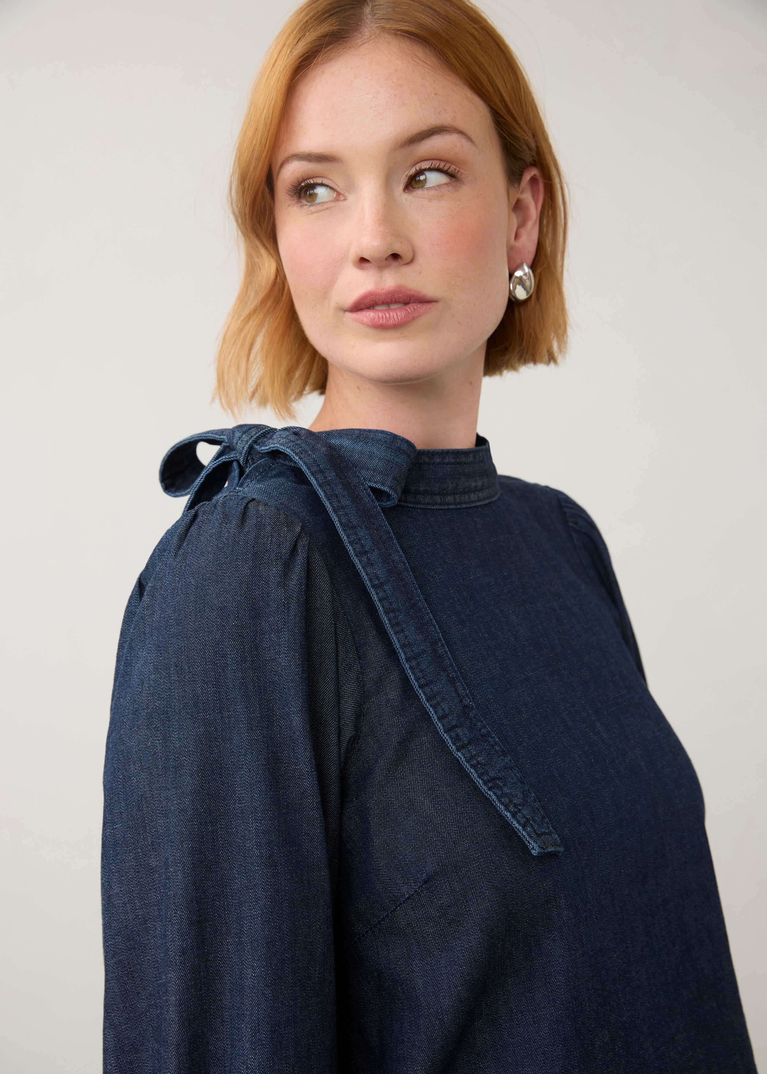 Close-up of dark wash puff-sleeve top with shoulder bow tie detail by French Dressing Jeans (FDJ)