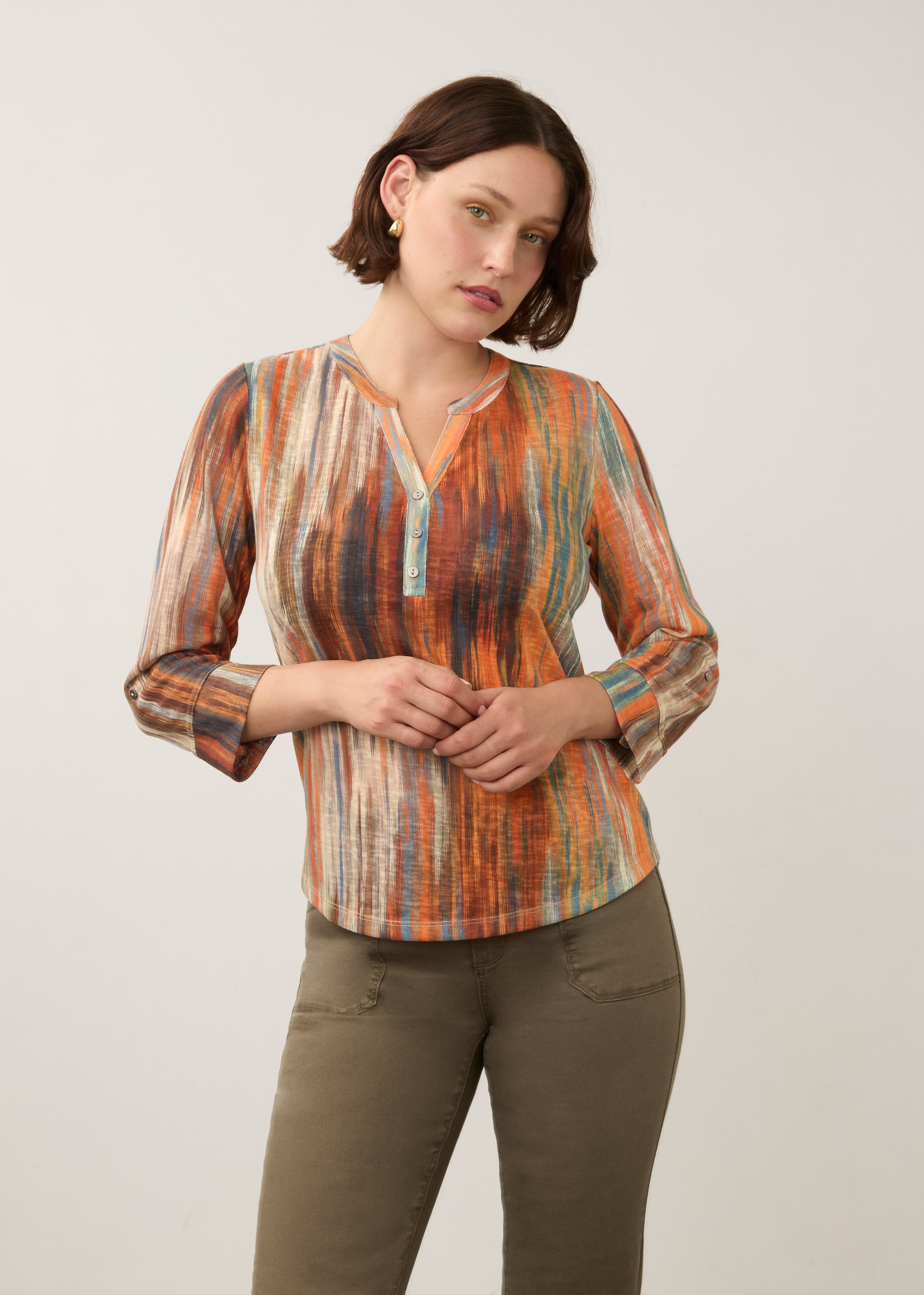 Front view of 3/4 sleeve Henley top in Heat color, button-front placket, paired with olive pants by French Dressing Jeans (FDJ)