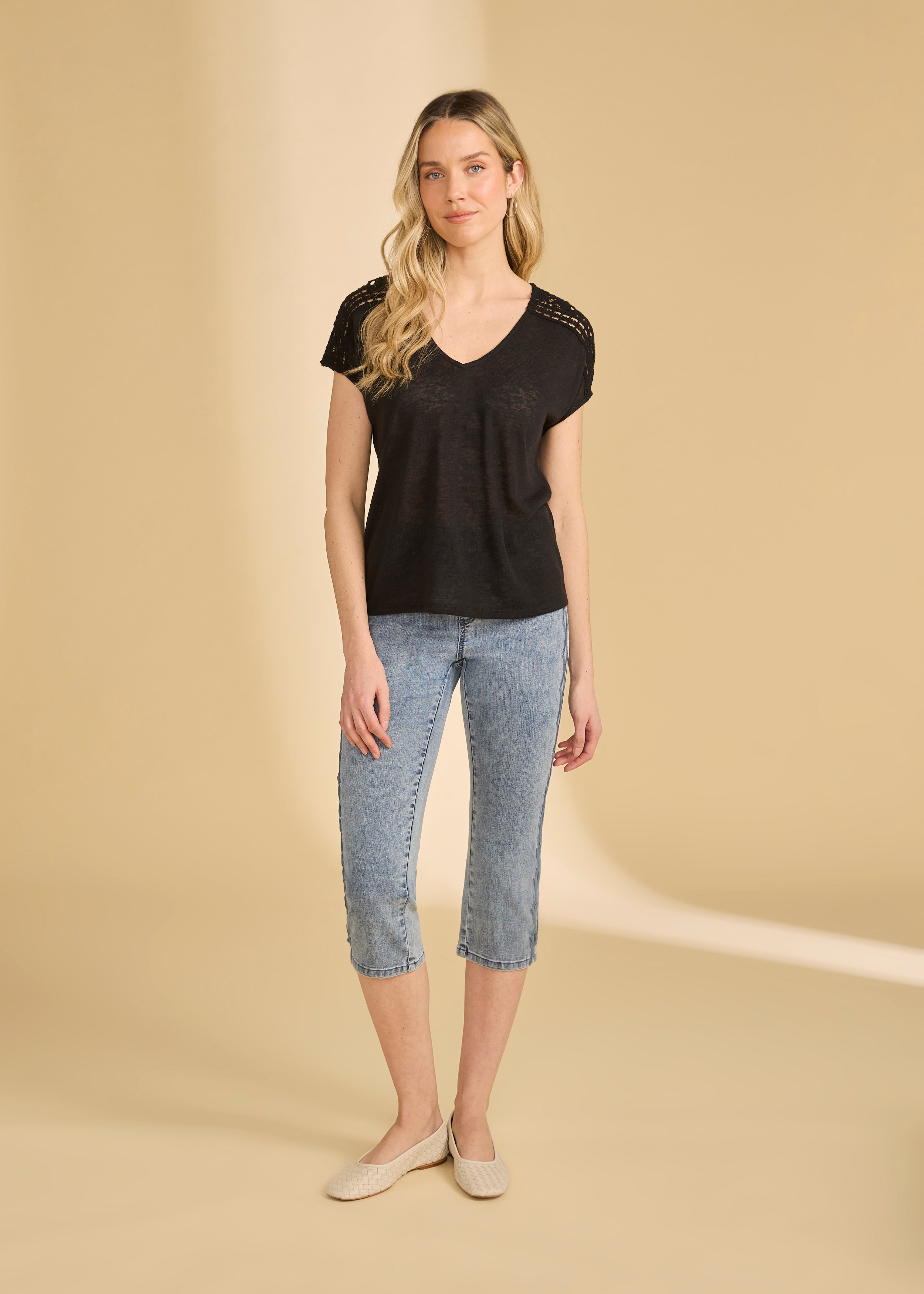 Full view of black V-neck top paired with light jeans and flats by French Dressing Jeans (FDJ)