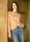 Model wearing polka dot sweater with tan and white dots, posing by French Dressing Jeans (FDJ)