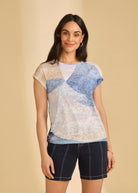 Front view of short-sleeve top in abstract blue and beige pattern paired with navy shorts by French Dressing Jeans (FDJ)
